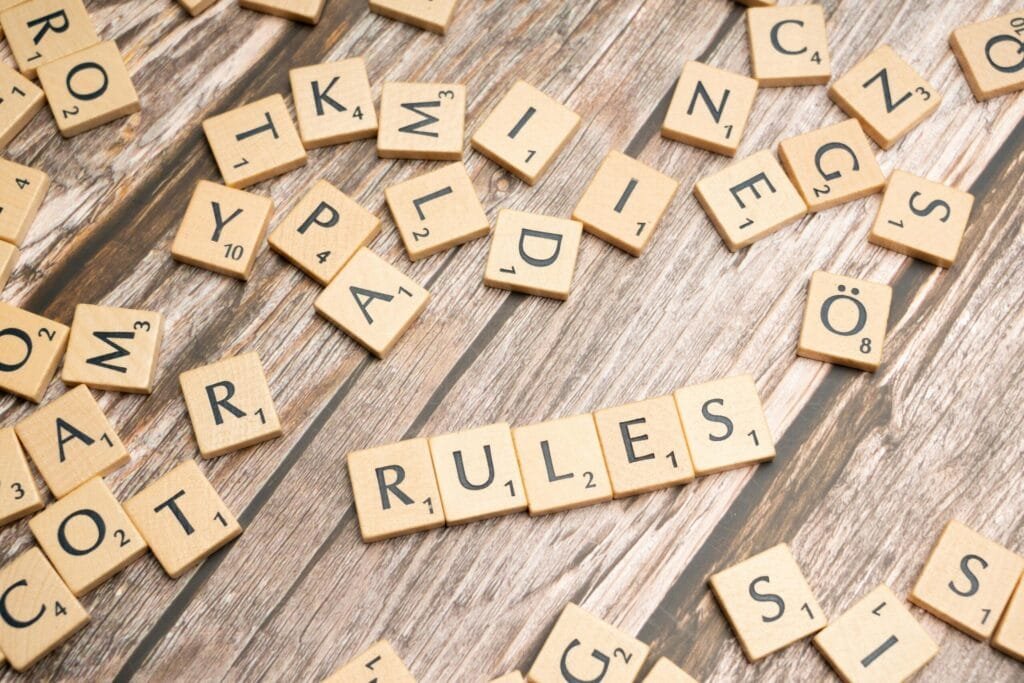 scrabble letters spelling rules on a wooden table